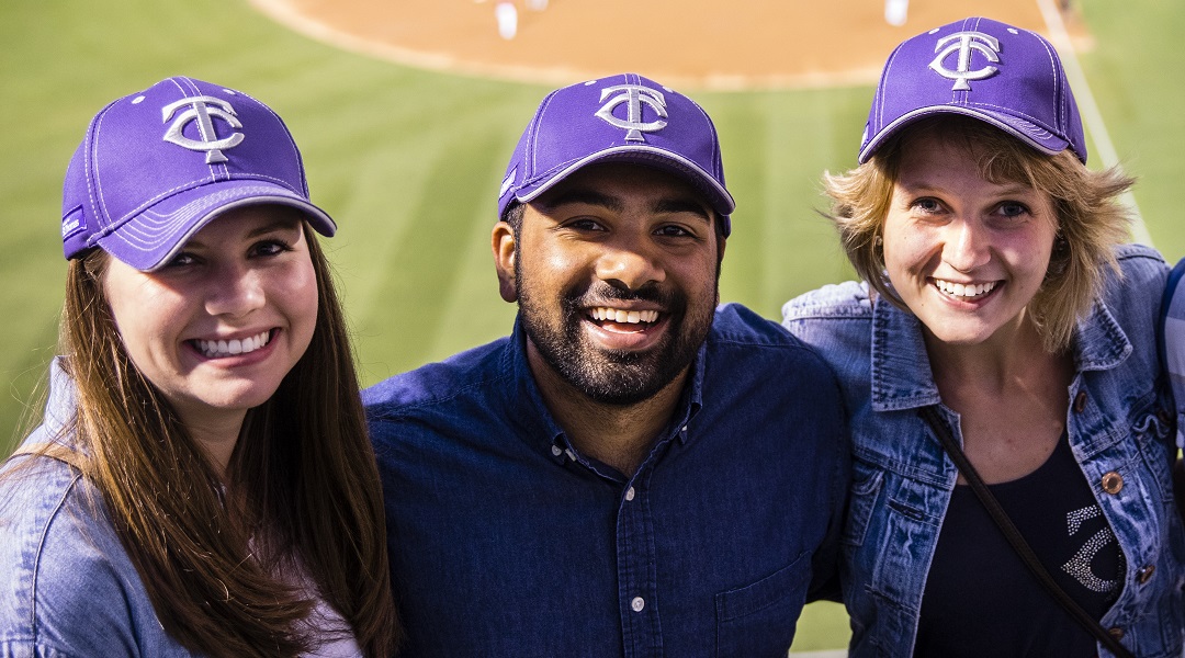 Tommies wearing purple hats at a Twins baseball game